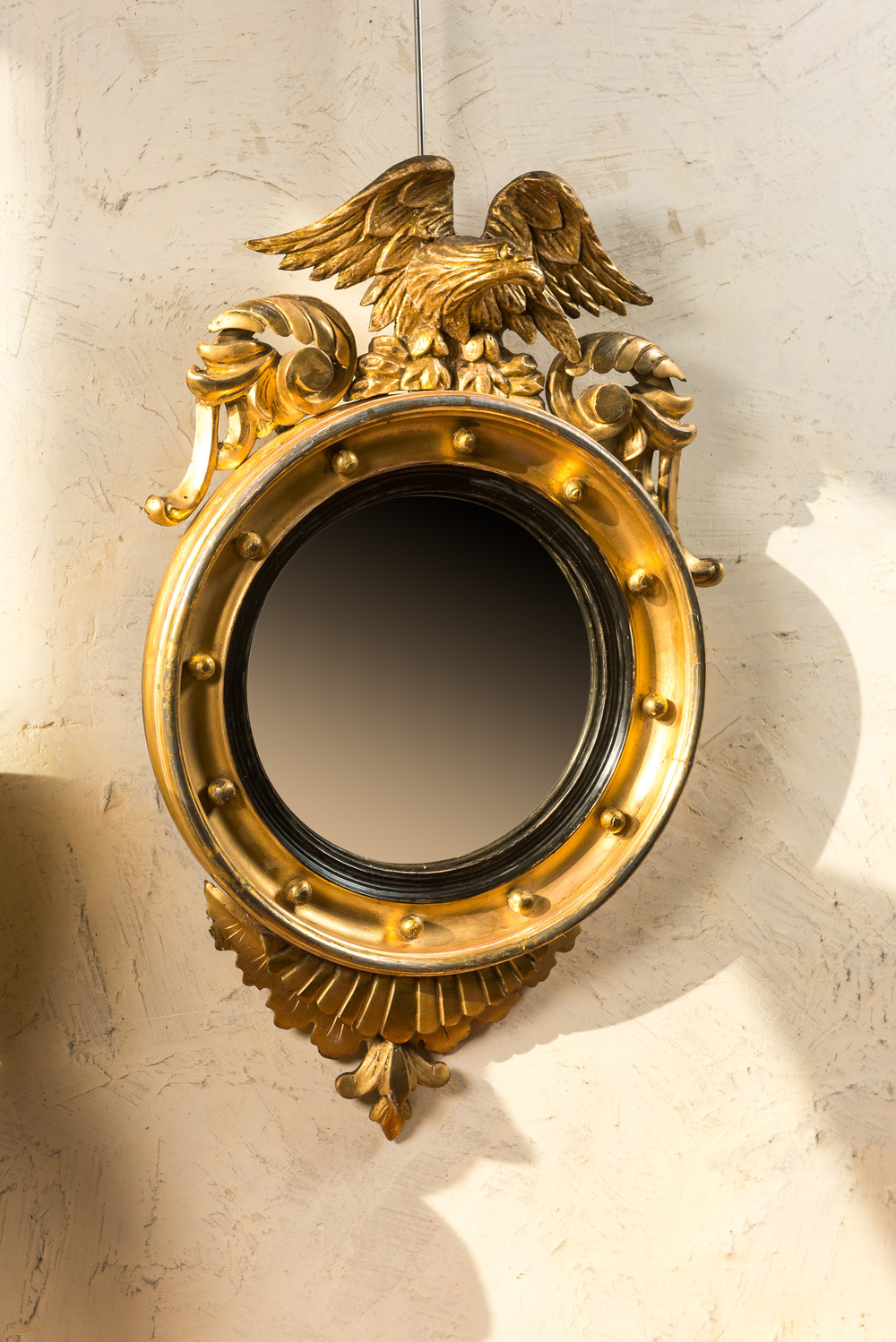 Miroir couronn&eacute; d'un aigle en bois dor&eacute; &agrave; m&eacute;daillon int&eacute;rieur noirci, vers 1900