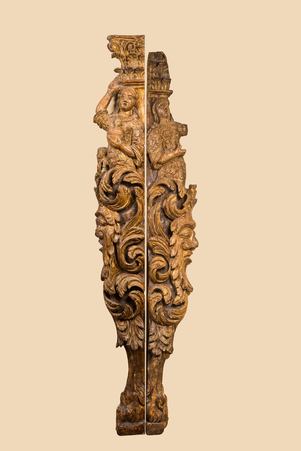 Een paar grote vergulde houten reli&euml;fs van zuilfragmenten met mascarons, 17e eeuw