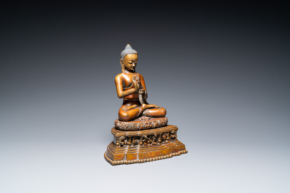 A large Tibetan brass and copper Buddha on throne, probably 16th C.