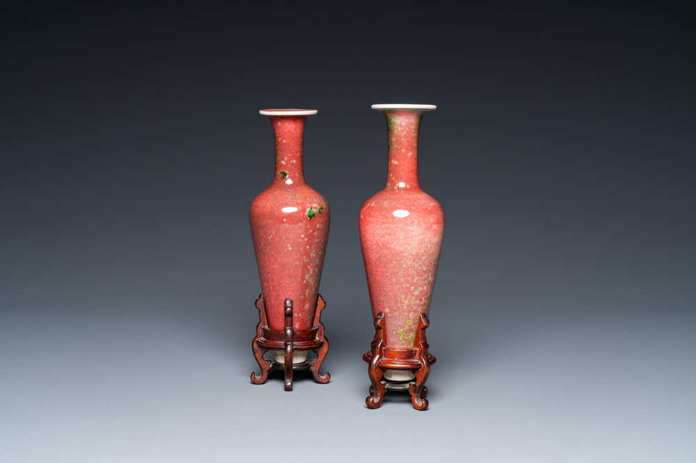 A pair of Chinese peachbloom-glazed vases on wooden stands, Kangxi mark, 19th C.