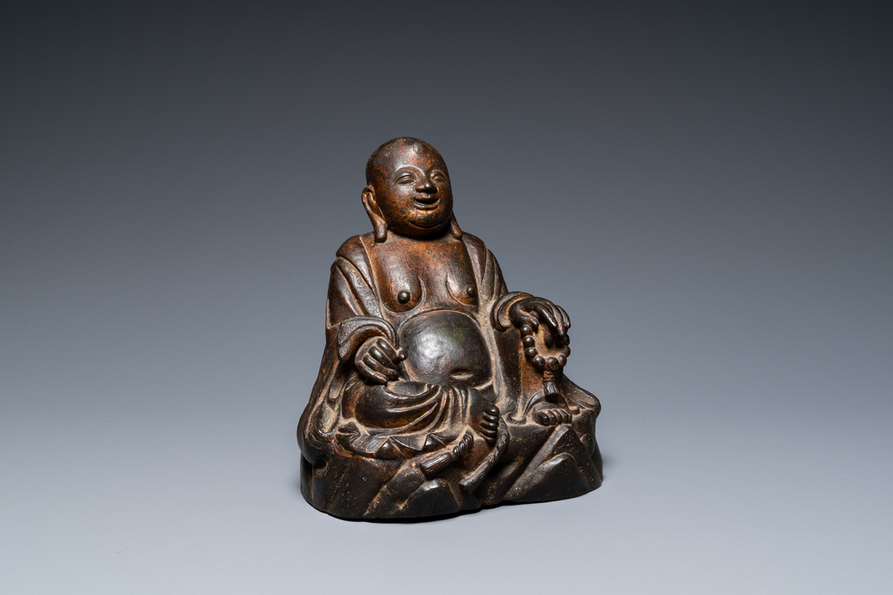 A Chinese gilt bronze figure of Buddha seated on a rock, Ming