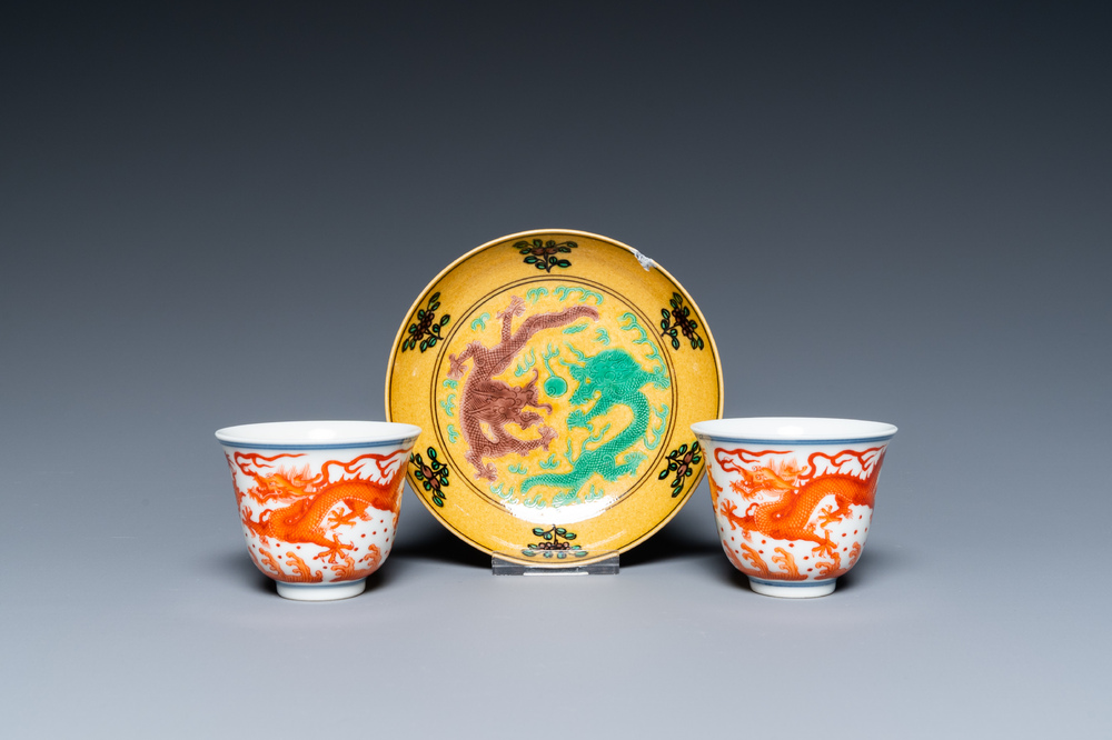 A pair of Chinese iron-red-decorated 'dragon' cups and a yellow-ground 'dragon' saucer, 19/20th C.