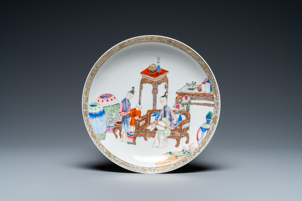 A fine Chinese famille rose eggshell porcelain plate with a boy and two governesses in an interior, Yongzheng