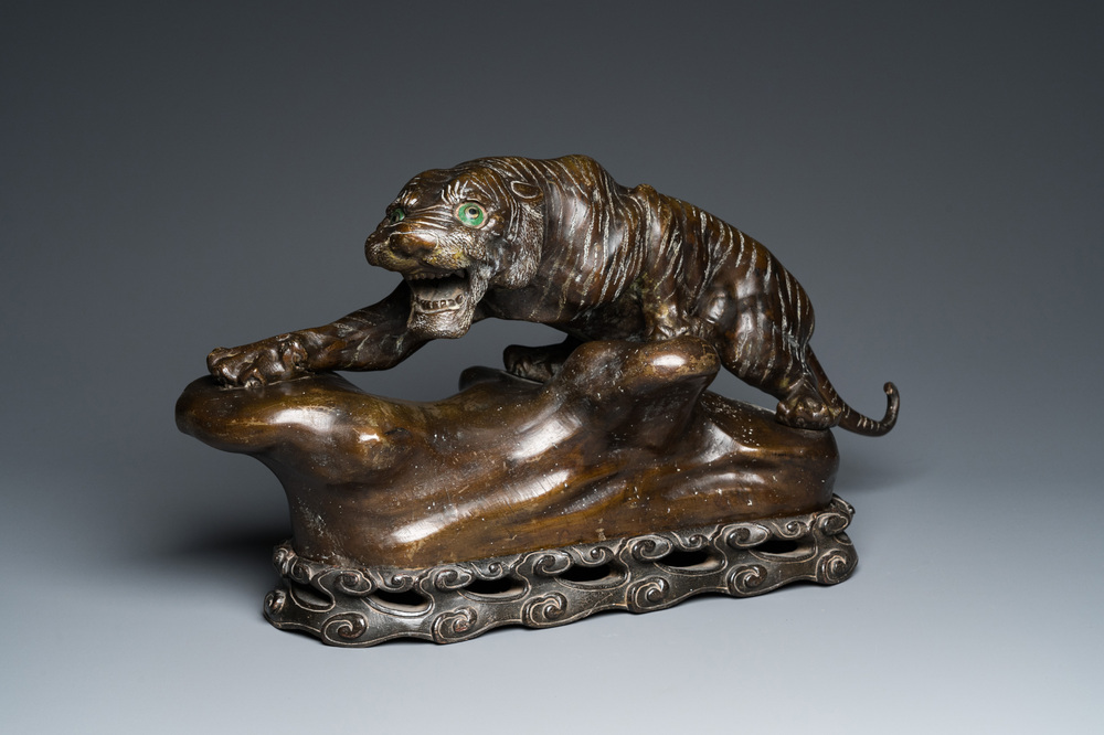 A large Vietnamese bronze tiger on a carved wooden stand, 19/20th C.