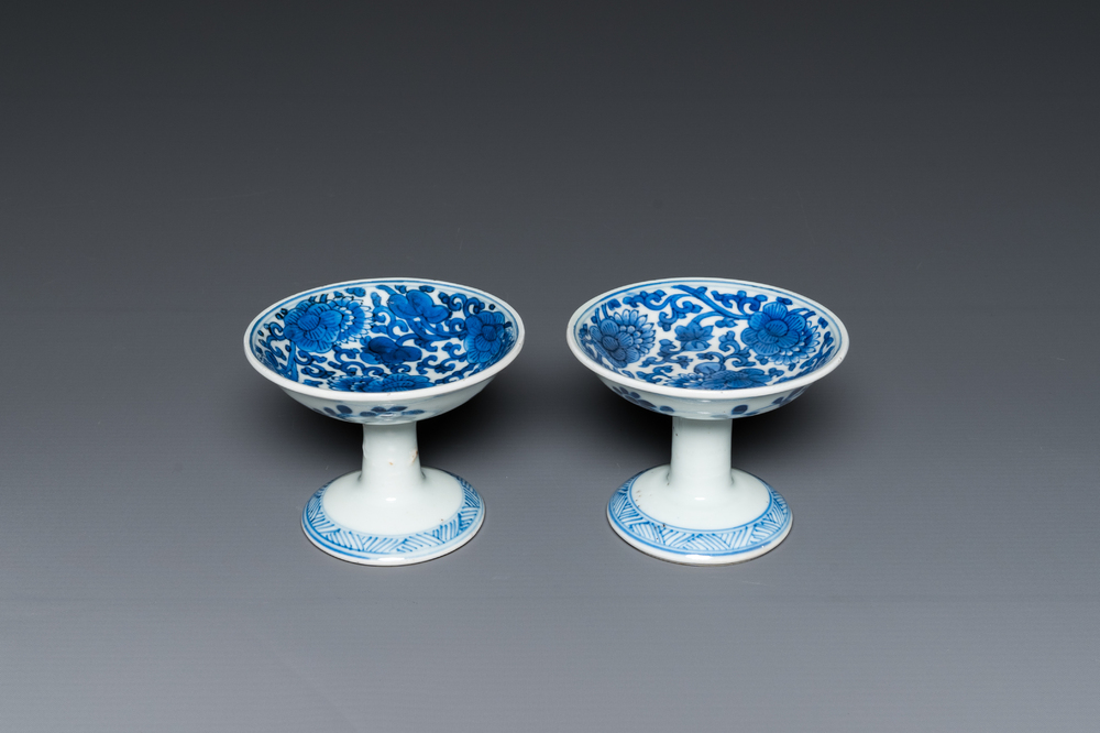 A pair of Chinese blue and white 'lotus scroll' stem cups, Kangxi