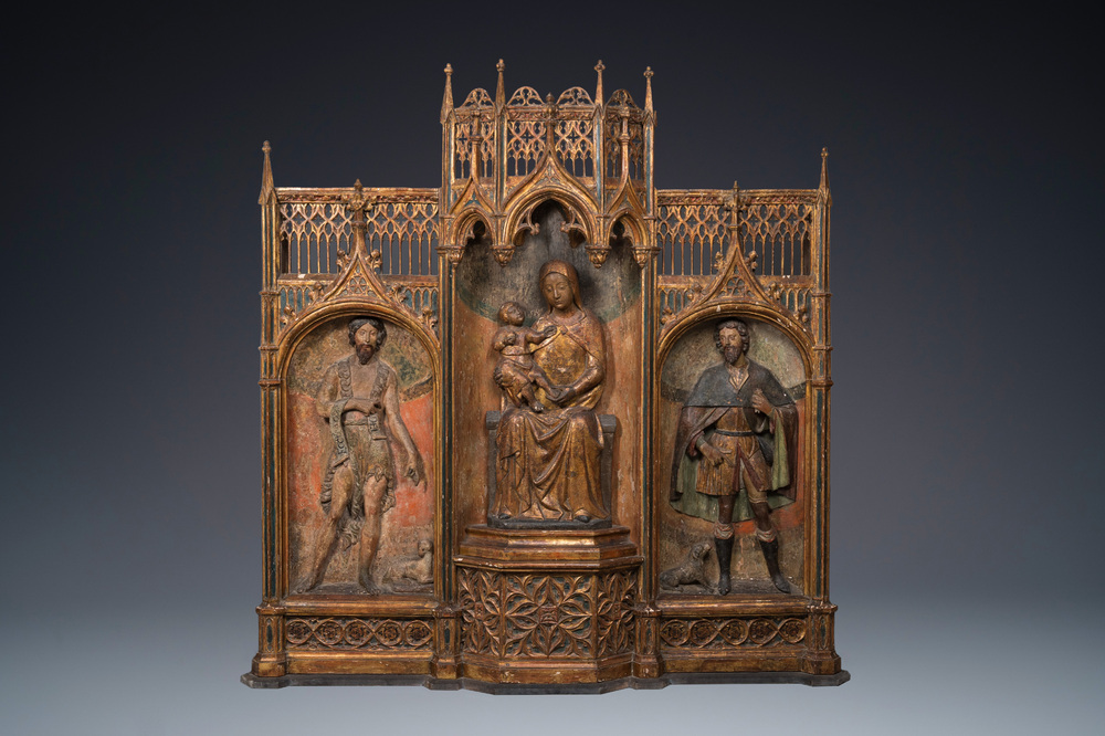 A large Spanish gilt and polychromed wooden tryptich retable with Saint John the Baptist, the Virgin Mary and Saint Roch, 1st half 16th C.