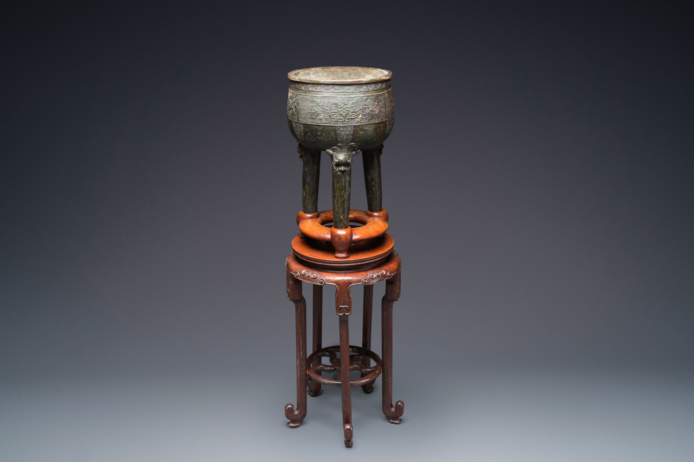 A large Chinese tripod censer on wooden base and display stand, Qing