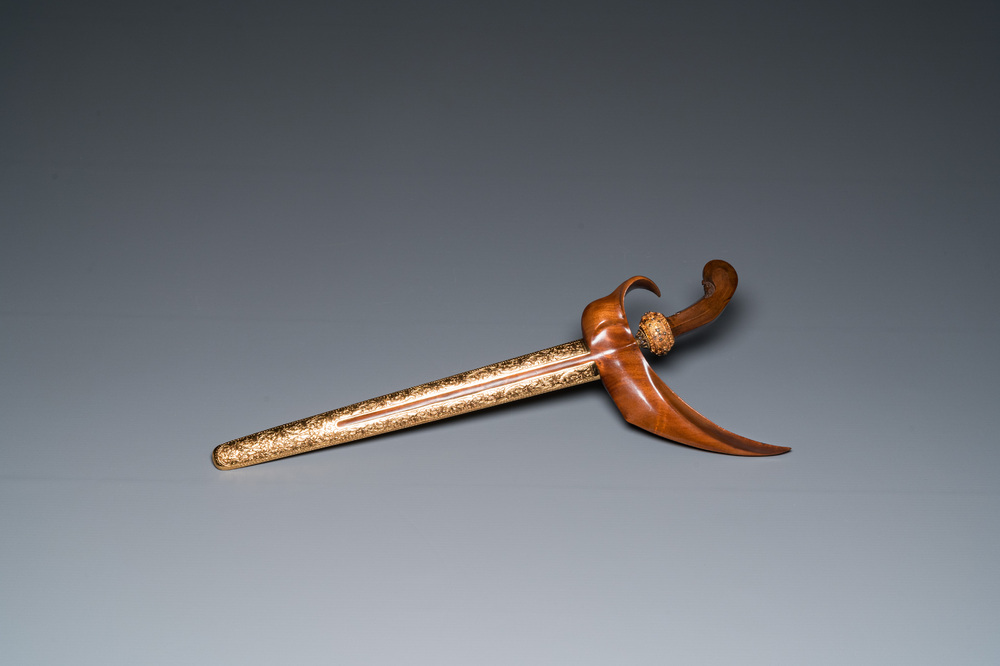 An Indonesian 'kris' or 'keris' dagger in polished Javanese wood with gilt copper and precious stones, 19th C.