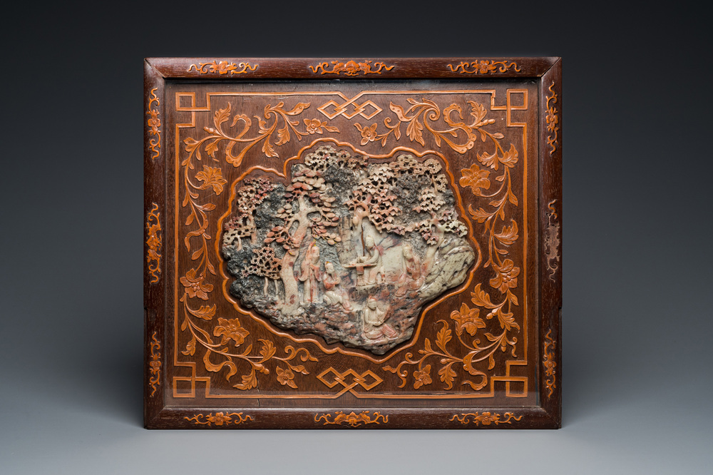 Een Chinees zeepstenen reli&euml;f met wijzen in een bos in fraai belegde houten lijst, 19e eeuw