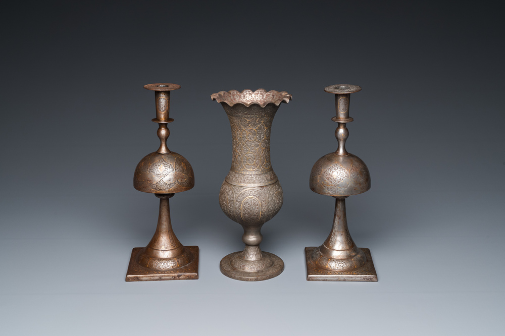 A pair of Qajar damascened candlesticks and a vase, Persia, 19th C.