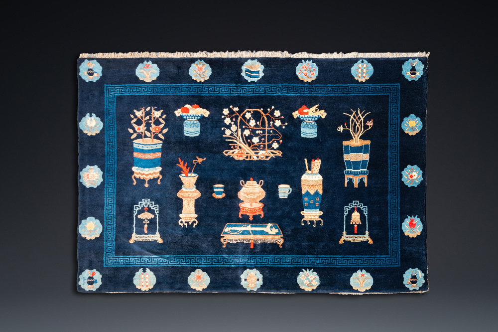 Een groot Chinees tapijt met decor van antiquiteiten op blauwe fondkleur, 19e eeuw