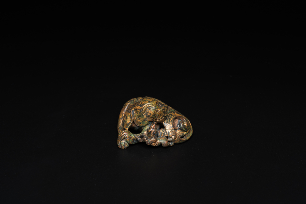 A Chinese gilt bronze &lsquo;dog&rsquo; scroll weight, Ming