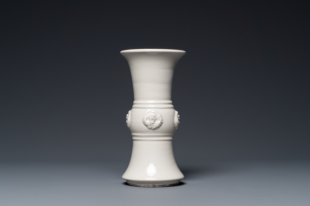 Vase de forme 'gu' en porcelaine blanc de Chine orn&eacute; de t&ecirc;tes de dragons, 18/19&egrave;me
