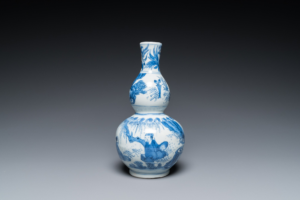 A Chinese blue and white double gourd vase with figures in a landscape, Transitional period