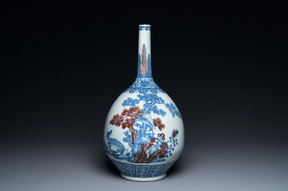 A Chinese blue, white and copper-red bottle vase with a deer and birds among blossoming branches, 19th C.