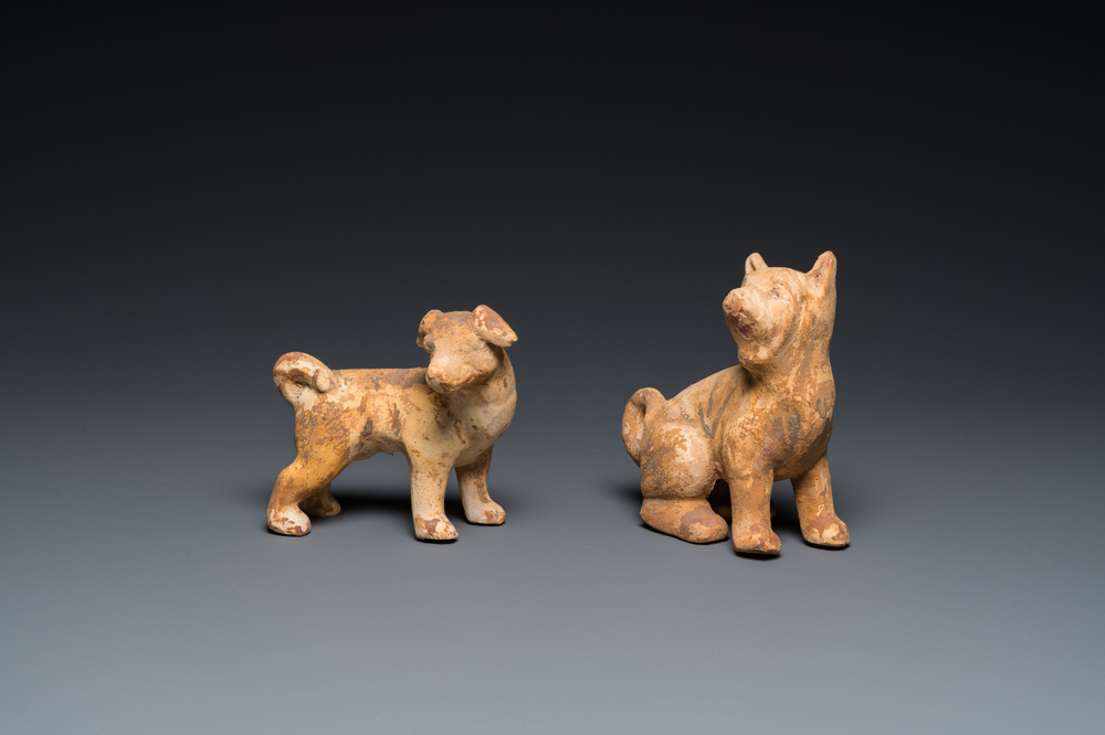 Twee Chinese 'mingqi' beschilderde aardewerken modellen van honden, Han