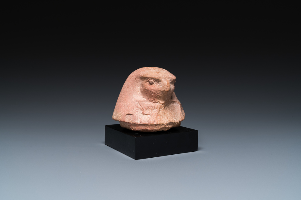 An Egyptian light brown limestone canopic lid in the shape of a falcon head, Late Period