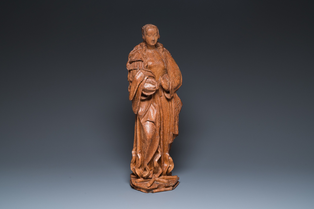 A Flemish carved oak sculpture of a female saint on a pyre, Brabant region, first half 16th C.