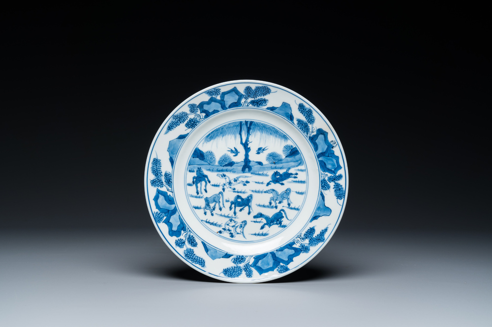 Assiette en porcelaine de Chine en bleu et blanc &agrave; d&eacute;cor des 'Huit chevaux de Mu Wang', Kangxi
