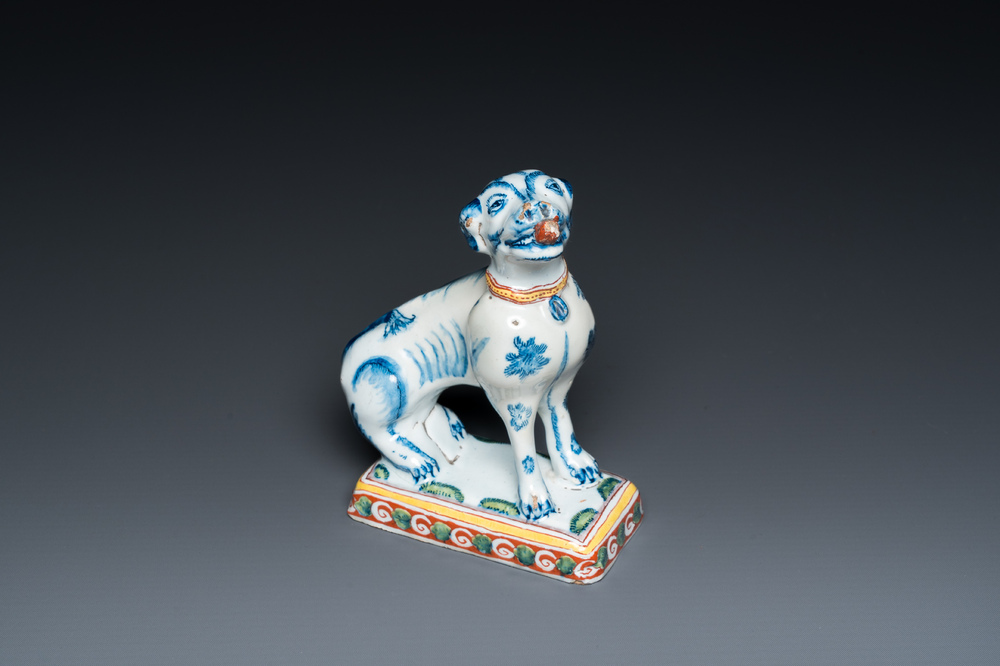 A polychrome Dutch Delft dog seated on a plinth, 18th C.