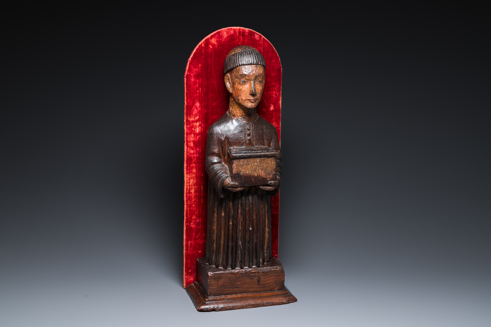 A partly gilded and polychromed wood sculpture of a monk holding a chest, probably Spain, 16th C.