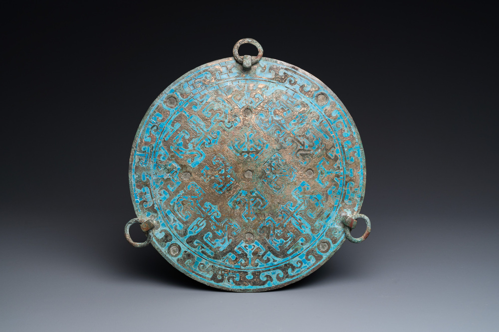 A large Chinese bronze mirror with turquoise and gold or gilt silver inlays, Warring States Period