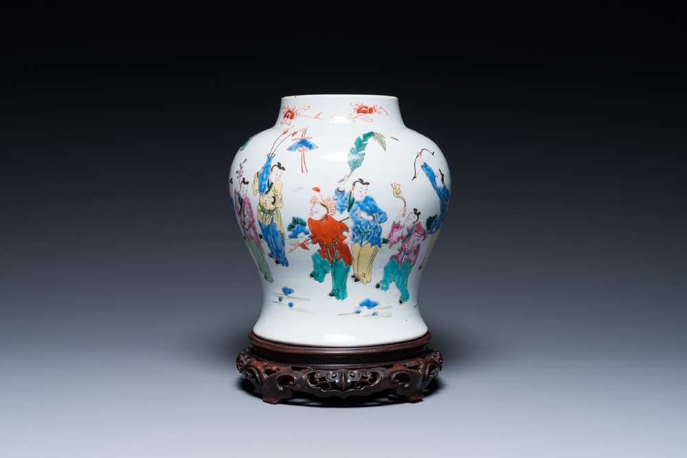 A Chinese famille rose 'playing boys' vase on a fine carved wooden stand, Yongzheng
