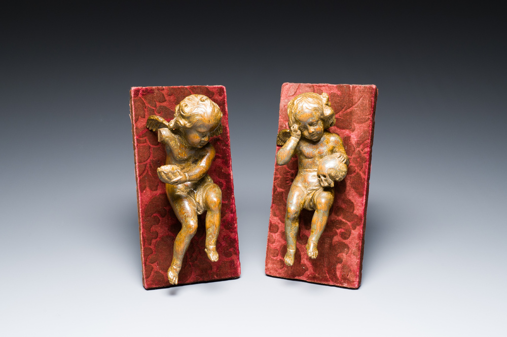 A pair of Flemish allegorical carved wood angels holding a Vanitas skull (Death) and a shell-shaped bowl (Life), 17th C.
