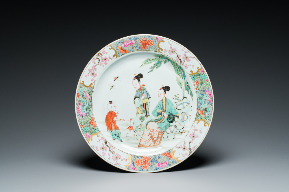 A Chinese famille rose dish with two ladies and a boy in a garden, Yongzheng