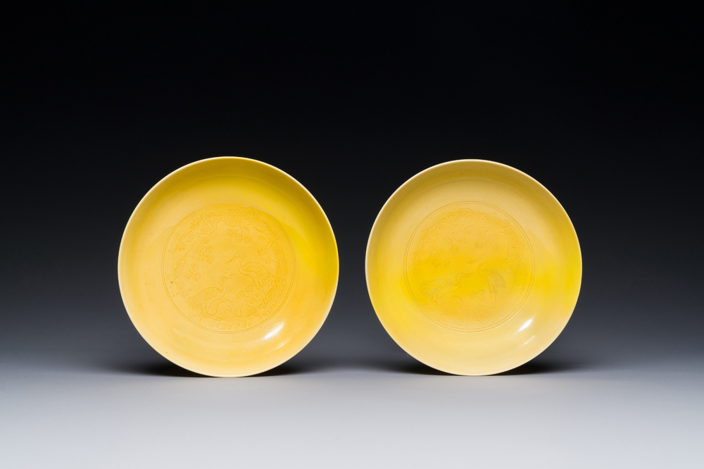 Paire de soucoupes en porcelaine de Chine en jaune monochrome &agrave; d&eacute;cor de pin et grue, marque et &eacute;poque de Yongzheng