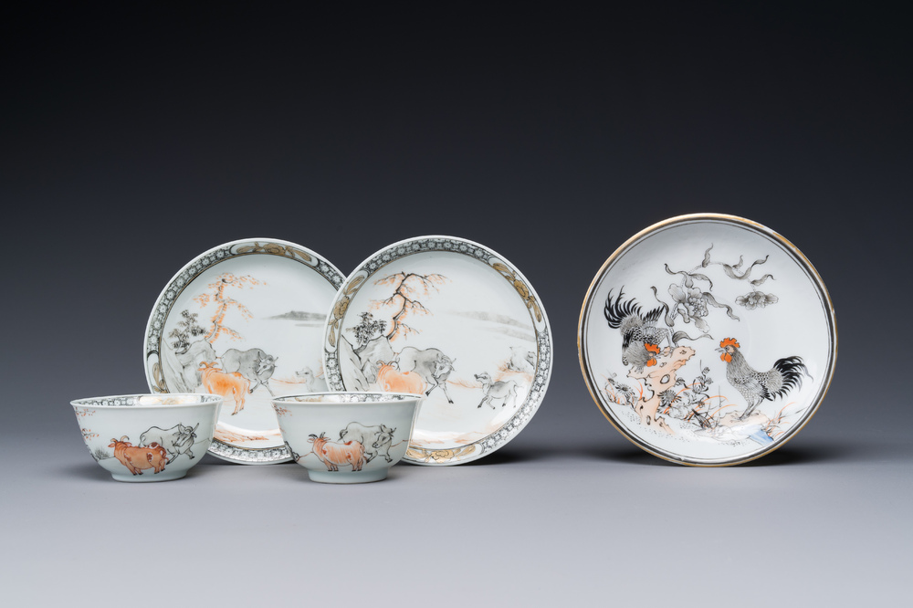 A pair of Chinese grisaille and iron-red 'buffalo' cups and saucers and a 'rooster' saucer, Yongzheng