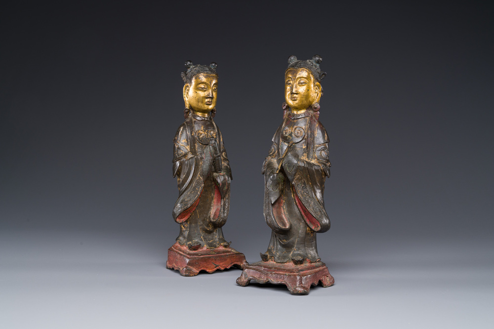 A pair of Chinese partly lacquered and gilt bronze figures of female attendants, Ming