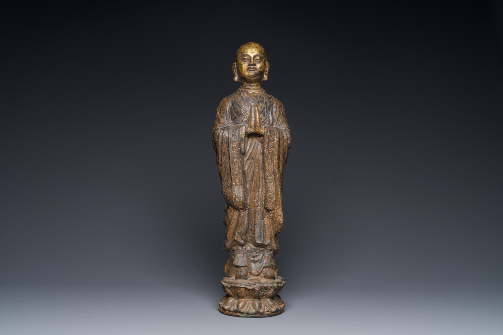 A Chinese gilt cast iron figure of a standing monk, Ming