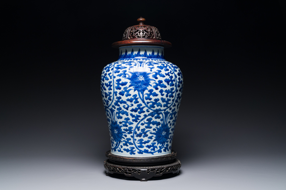 Pot en porcelaine de Chine en bleu et blanc &agrave; d&eacute;cor de rinceaux de lotus au couvercle et socle en bois, Kangxi