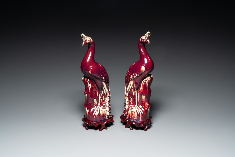 A pair of Chinese flamb&eacute;-glazed models of peacocks on wooden stands, 19th C.