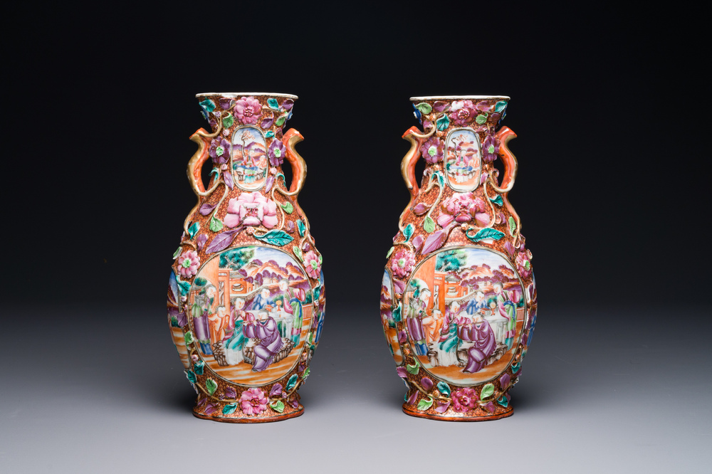 A pair of Chinese Canton famille rose 'mandarin subject' vases with floral relief design, Qianlong