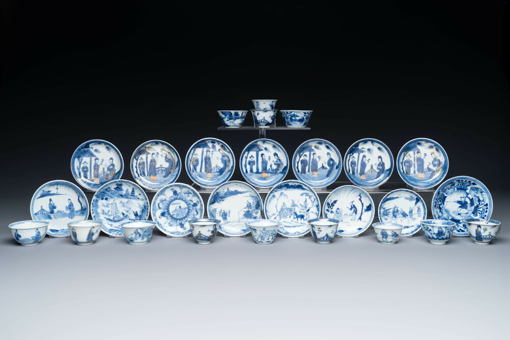 Thirteen Chinese blue and white saucers and twelve cups with figural design, Kangxi/Yongzheng