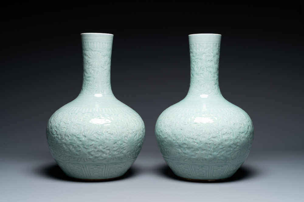 A pair of large Chinese monochrome celadon-glazed anhua 'lotus scroll' bottle vases, 19th C.