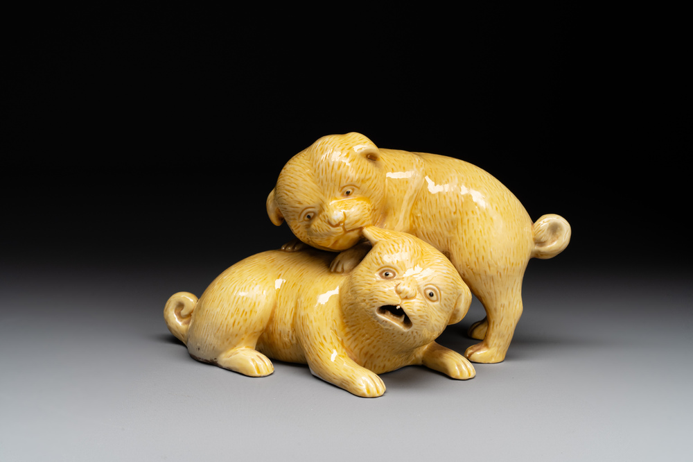 A Chinese monochrome yellow-glazed group of two playing dogs, 19th C.