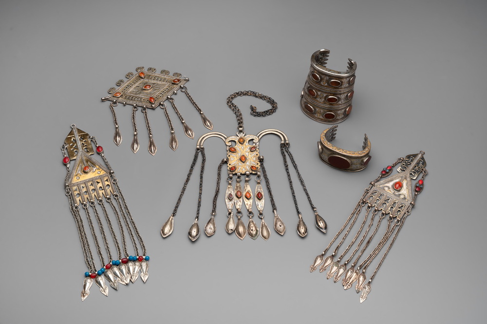 Two silver bracelets, two pendants with carnelian stones, a silver back ornament and a silver capstone, Turkmenistan, 19/20th C.