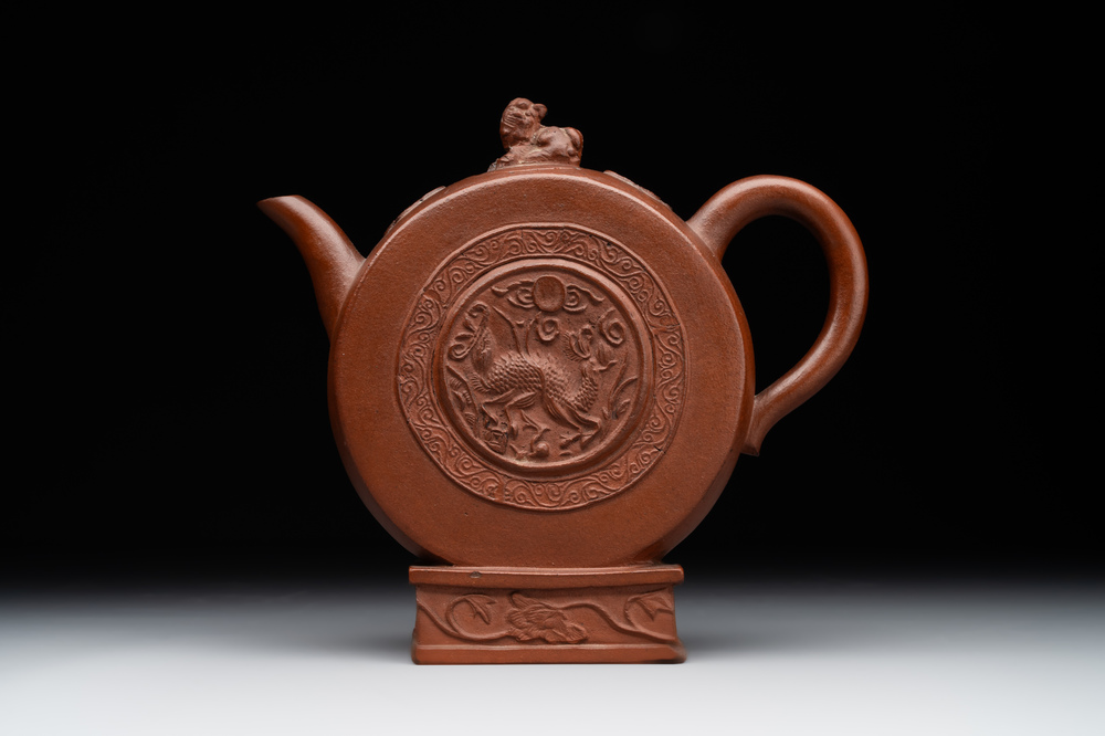 A Chinese circle-shaped Yixing stoneware 'kylin' teapot with relief design, Kangxi
