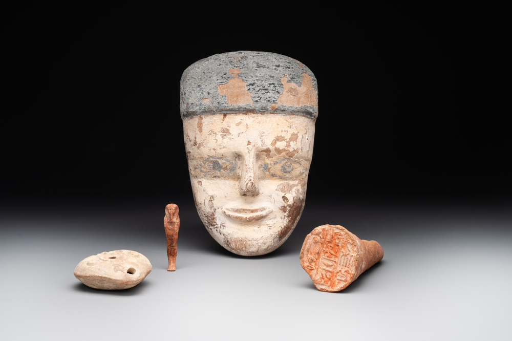 A death mask, a Ushabti, an oil lamp and a ritual cone with hieroglyphs, Egypt, 15th/1st C. B.C.
