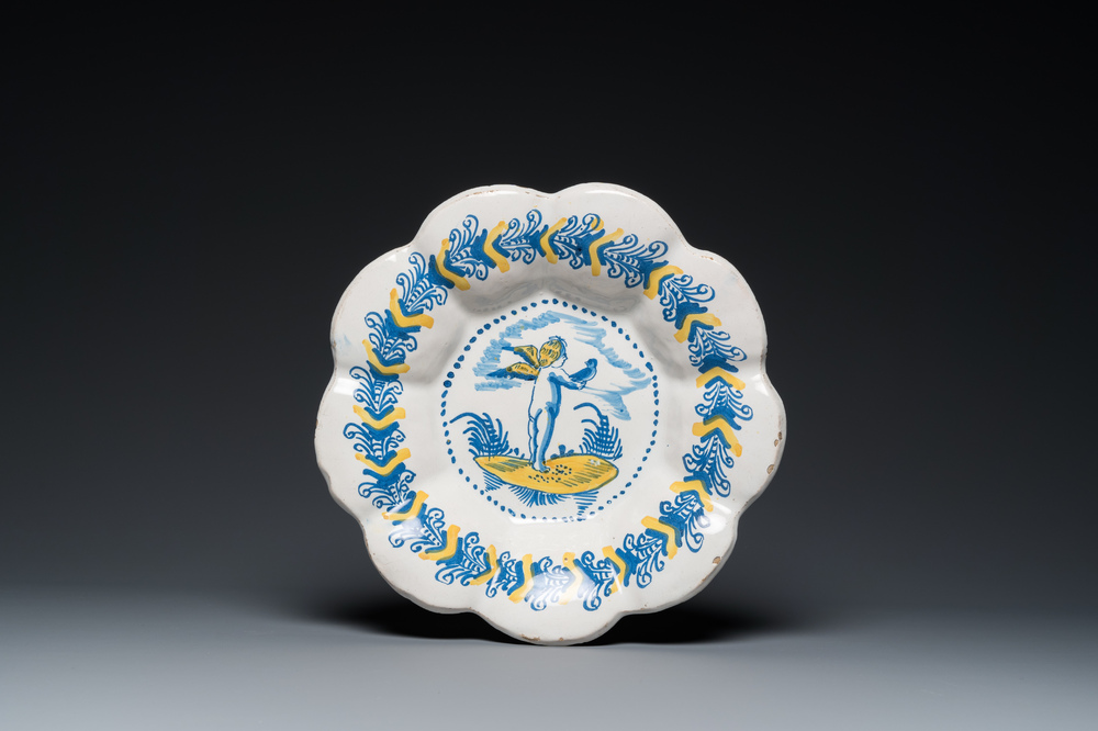 A blue, white and yellow Dutch Delftware dish with a putto holding a falcon, Delft or Haarlem, 17th C.