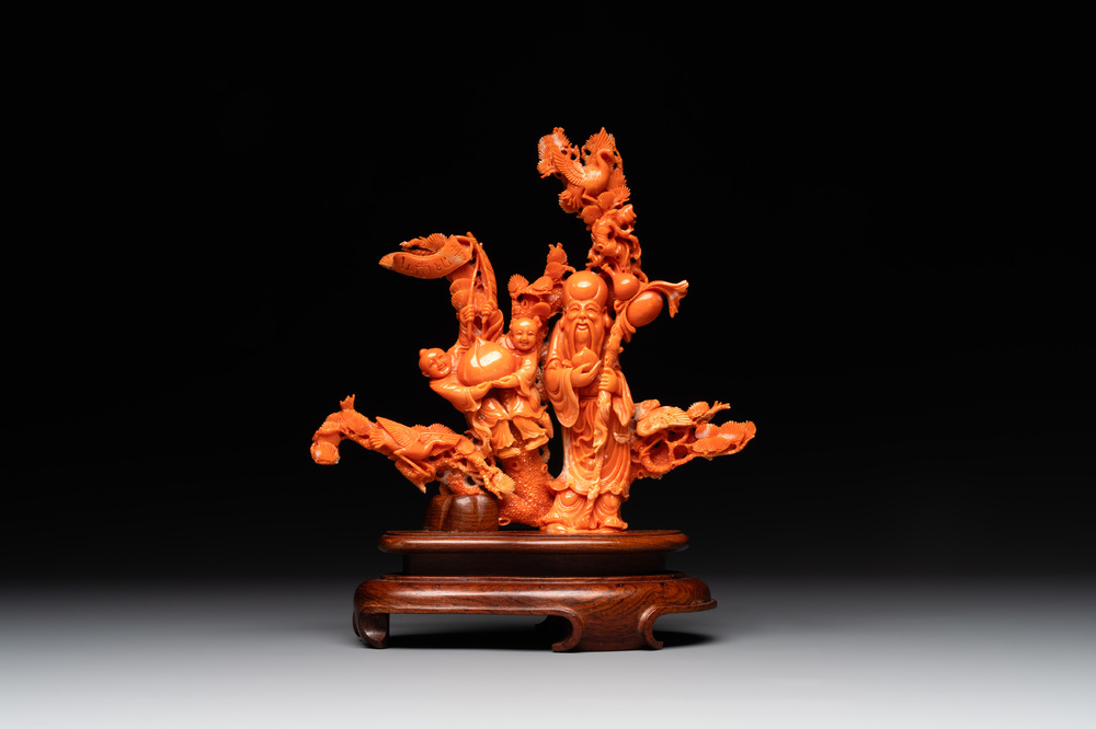 A Chinese red coral group of Shoulao with two boys holding a peach, inscribed 'Shou Bi Nan Shan 壽比南山', 19/20th C.