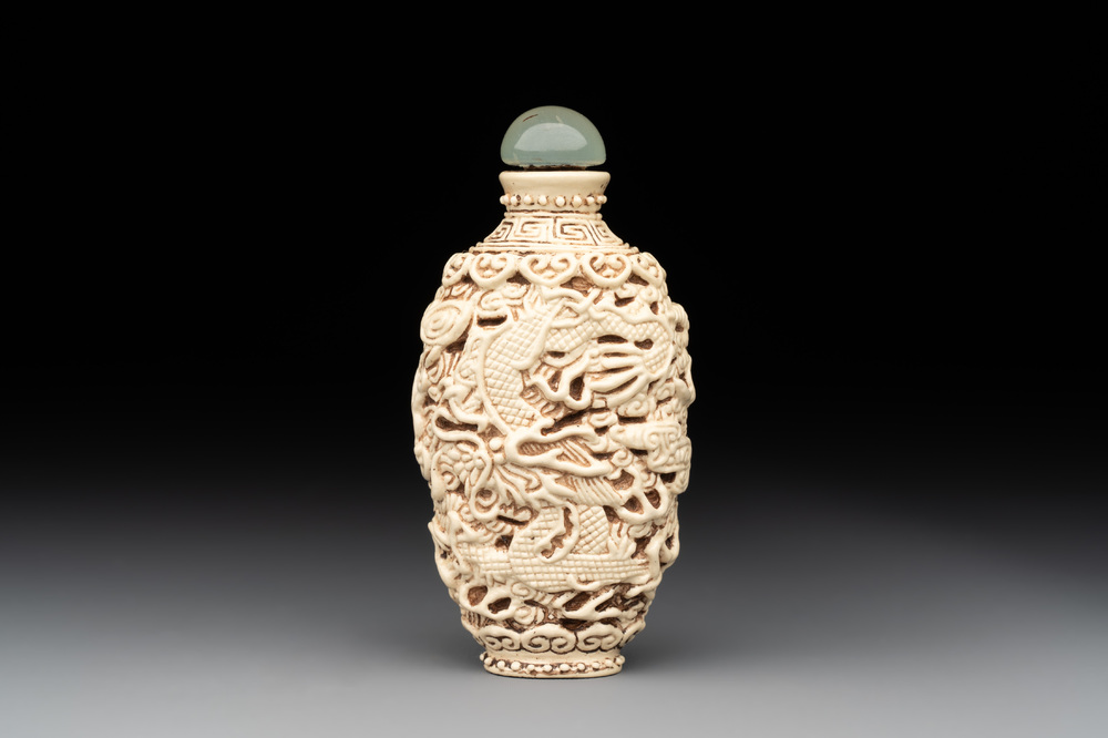 A Chinese moulded cream-glazed 'dragon and phoenix' snuff bottle, Jiaqing mark, 19th C.