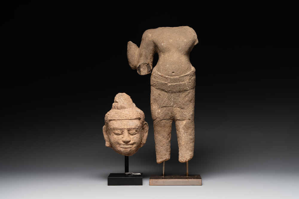 A sandstone torso and a Buddha head, Cambodia, late Khmer period, 13/14th C.