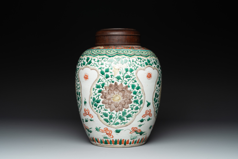 A Chinese famille verte jar with floral design and a wooden cover, Kangxi
