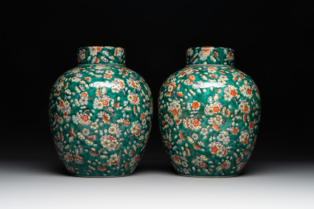 A pair of Chinese famille verte green-ground 'prunus' jars and covers, 19th C.