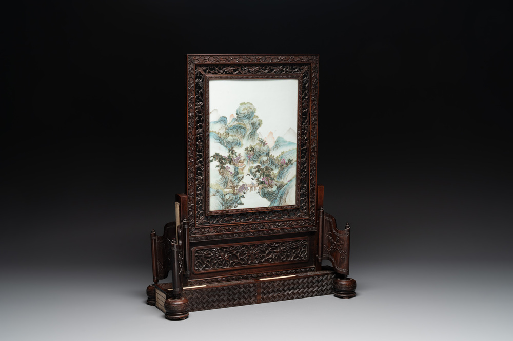 A large Chinese carved wooden table screen with a fine famille rose 'landscape' plaque, 19th C.