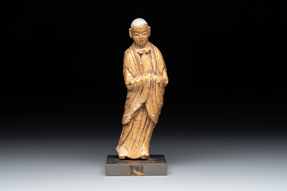 A Chinese gilt and polychromed stucco figure of a monk, Ming